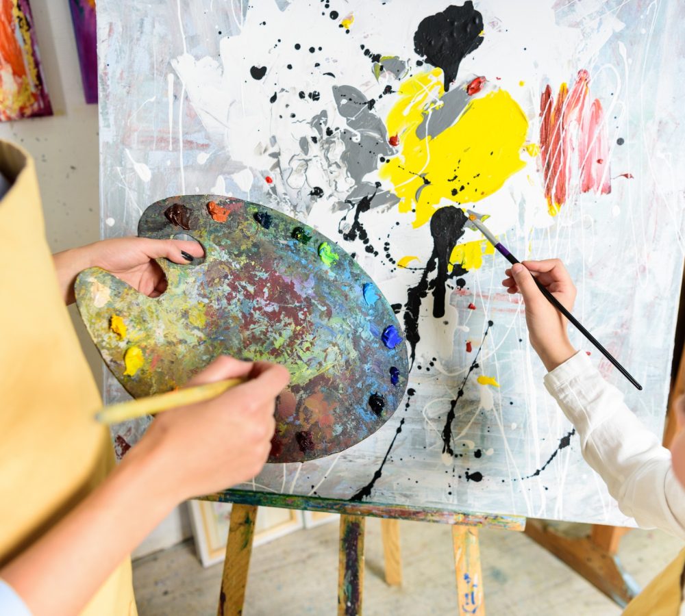 cropped-image-of-pupil-painting-on-lesson-in-workshop-of-art-school.jpg