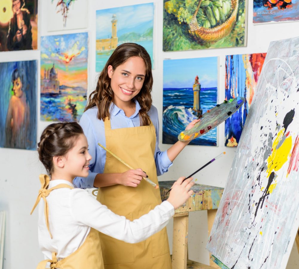 smiling-teacher-and-pupil-painting-in-workshop-of-art-school.jpg